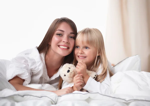Femme et jeune fille couchée au lit souriant — Photo