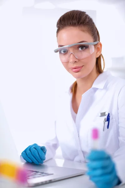 Woman researcher is surrounded by medical vials and flasks, isolated on white background — Stock Photo, Image