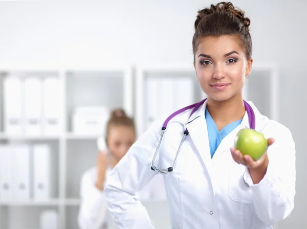 Femme médecin main tenant une pomme verte, debout — Photo