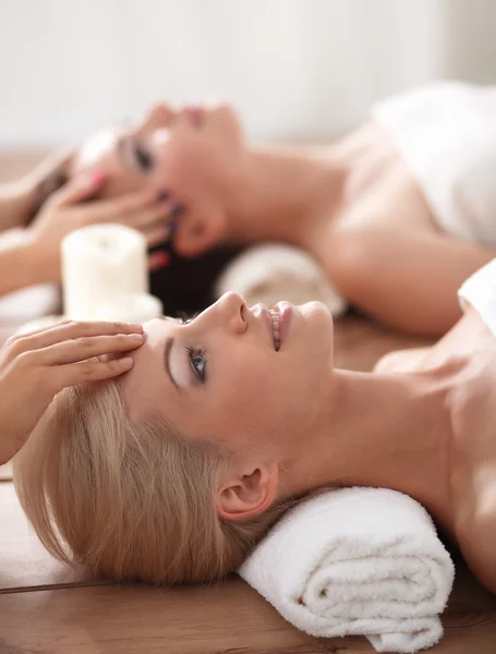 Dos mujeres hermosas jóvenes relajándose y disfrutando en el centro de spa — Foto de Stock