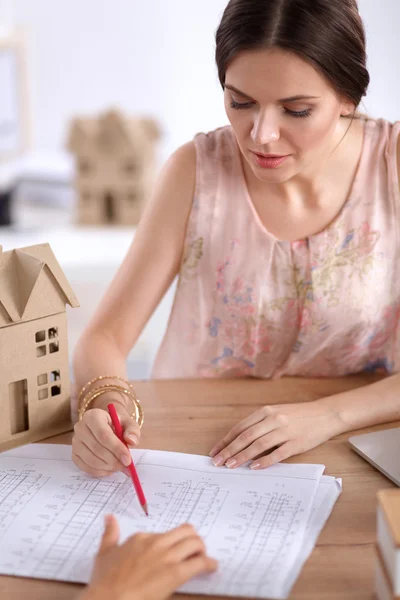 Aantrekkelijke zakenvrouw zit op het bureau in het kantoor — Stockfoto