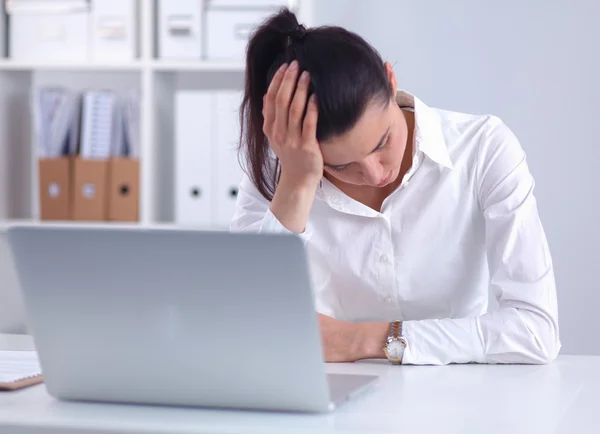 Mujer de negocios estresada sentada en el escritorio de la oficina —  Fotos de Stock