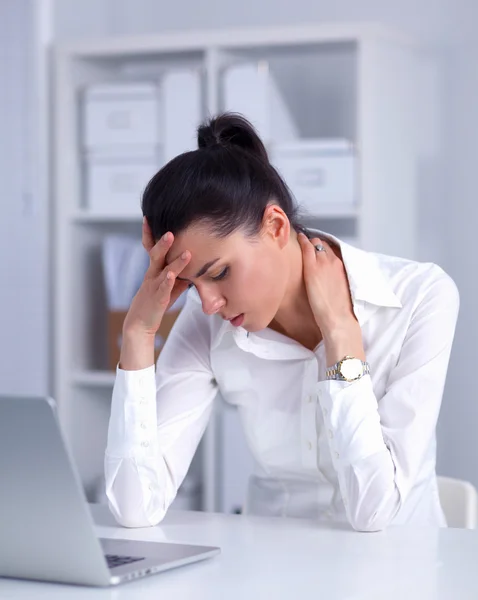 Стрессовая деловая женщина сидит за столом в офисе — стоковое фото