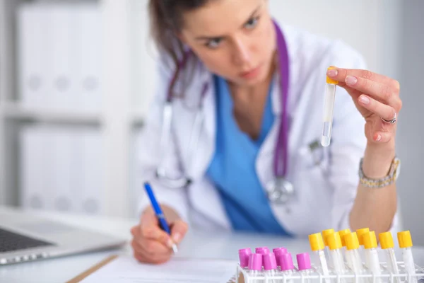 Woman researcher is surrounded by medical vials and flasks, isolated on white background — Stock Photo, Image