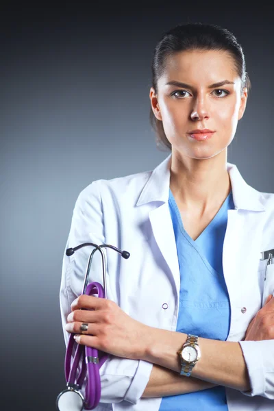 Retrato de una joven doctora sosteniendo un estetoscopio, aislada sobre fondo negro — Foto de Stock