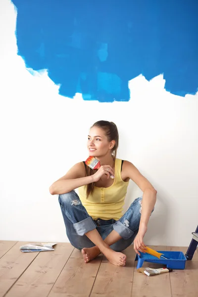 Retrato de pintora sentada en el suelo cerca de la pared después de pintar . — Foto de Stock