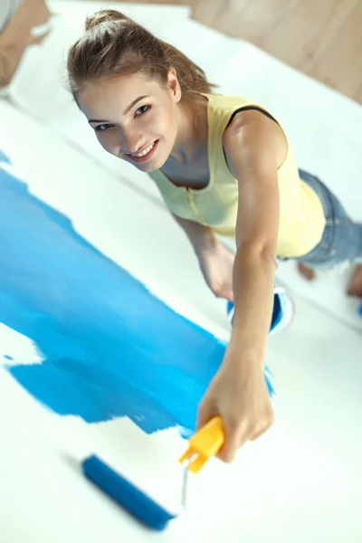 Frumoasa tanara femeie face pictura pe perete — Fotografie, imagine de stoc