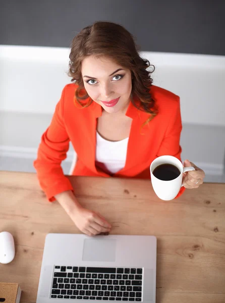 Attraktive Frau sitzt im Büro am Schreibtisch und arbeitet mit Laptop — Stockfoto