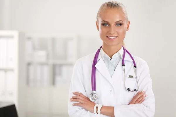 Portrait of young woman doctor with white coat standing in hospital — Stock Photo, Image