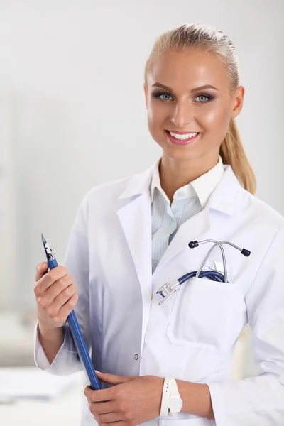 Lächelnde Ärztin mit Ordner in Uniform steht im Krankenhaus — Stockfoto