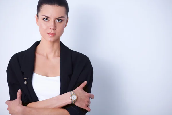 Jonge vrouw permanent, geïsoleerd op grijze achtergrond — Stockfoto