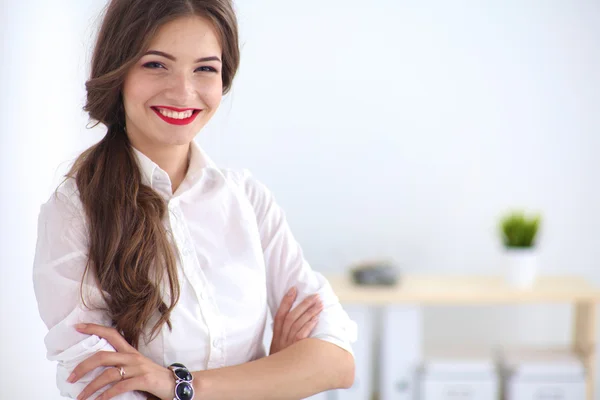 Attraktive Geschäftsfrau steht an Wand im Büro — Stockfoto