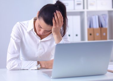 Ofiste masa başında oturan stresli iş kadını.