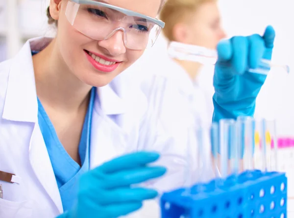 Woman researcher is surrounded by medical vials and flasks, isolated on white background — Stock Photo, Image