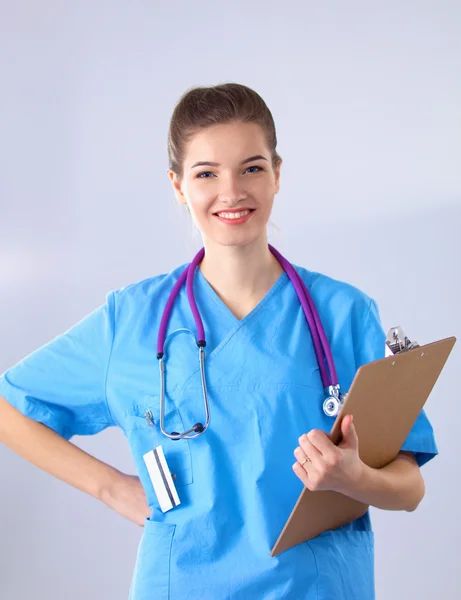 Lächelnde Ärztin mit Ordner in Uniform steht im Krankenhaus — Stockfoto