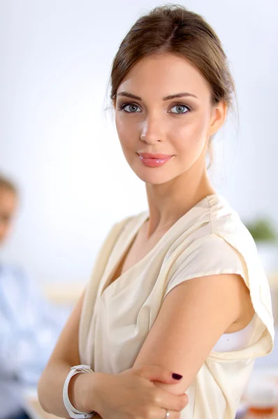 Attractive businesswoman standing near wall in office — Stock Photo, Image