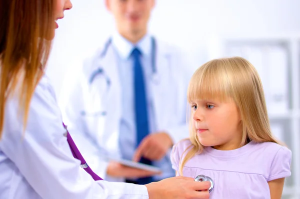 Médico femenino examinando a un niño con estetoscopio en cirugía — Foto de Stock