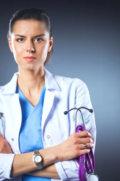 Porträtt av ung kvinnlig läkare som håller ett stetoskop, isolerad på svart bakgrund — Stockfoto