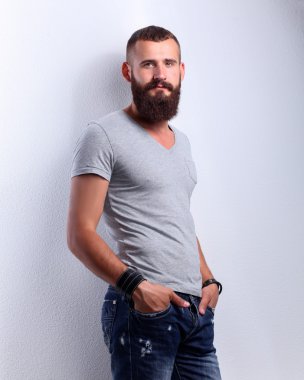 ayakta, gri arka plan üzerinde izole yakışıklı sakallı adam portresi