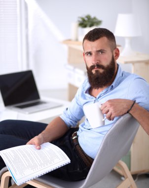 sandalye ile office kitapta oturan genç işadamı