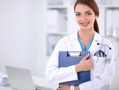 Hastanede üniformalı, gülümseyen bir kadın doktor.