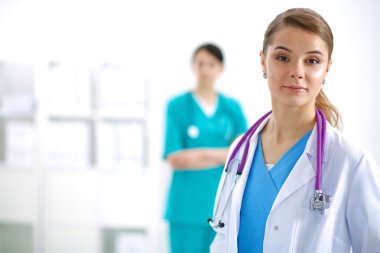 Kadın doktor hastanede steteskopla dikiliyor.