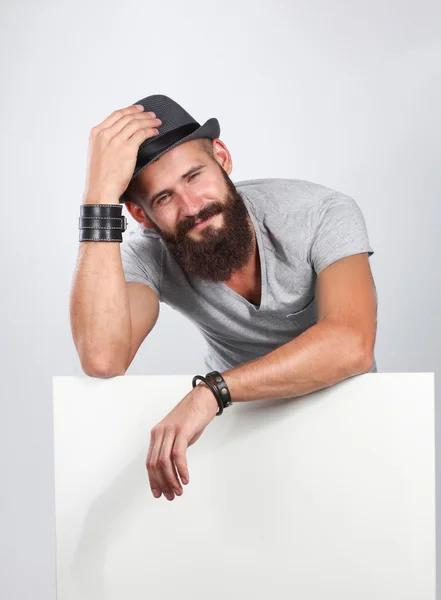 Retrato de un joven con sombrero de pie cerca del blanco, aislado sobre fondo blanco —  Fotos de Stock