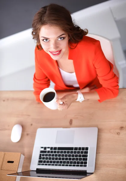 Attraktive Frau sitzt im Büro am Schreibtisch und arbeitet mit Laptop — Stockfoto