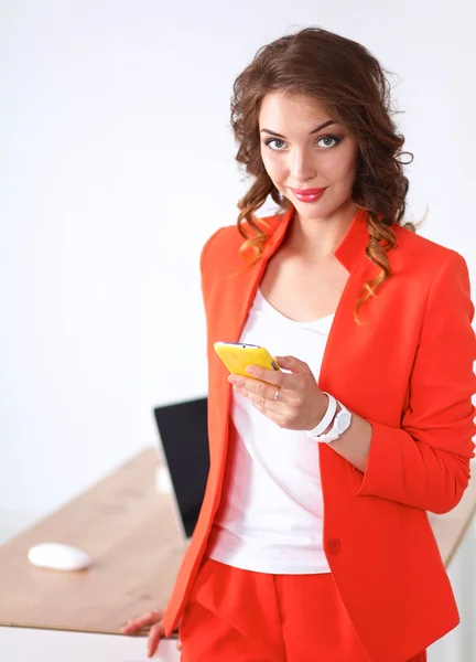 Belle femme d'affaires utilisant un téléphone portable debout dans le bureau — Photo