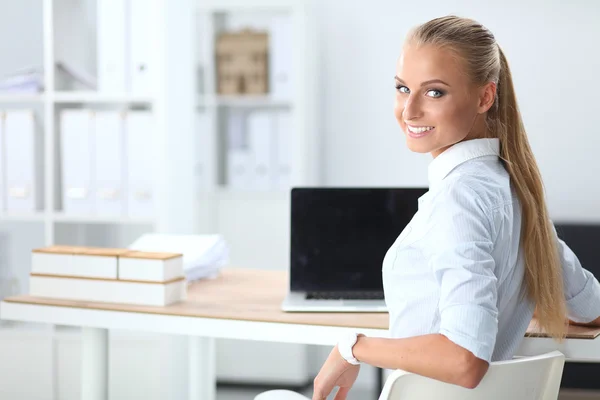 Attraente donna d'affari seduta su una scrivania con computer portatile in ufficio — Foto Stock