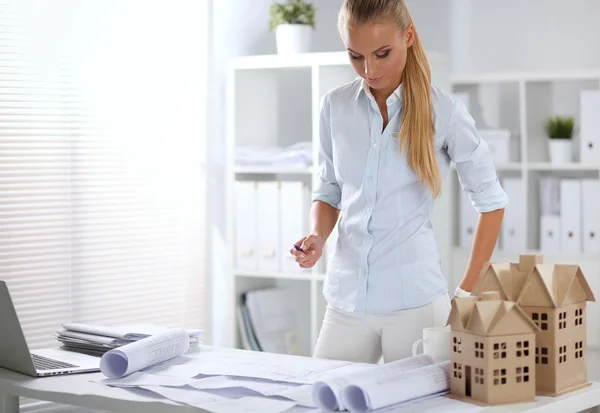 Portret van vrouwelijke architect met blauwdrukken aan de balie — Stockfoto