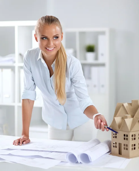 Portret van vrouwelijke architect met blauwdrukken aan de balie — Stockfoto