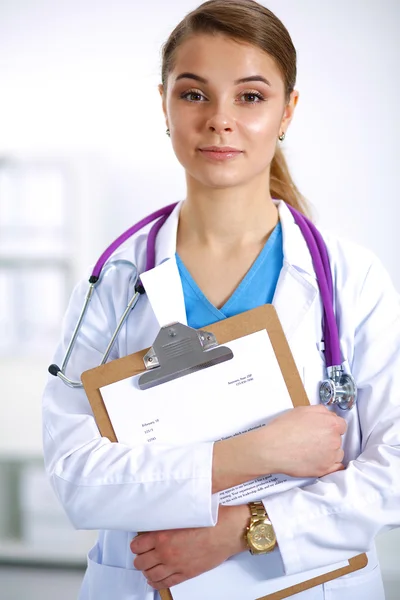 Woman doctor standing with folder at hospital — Stock Photo, Image