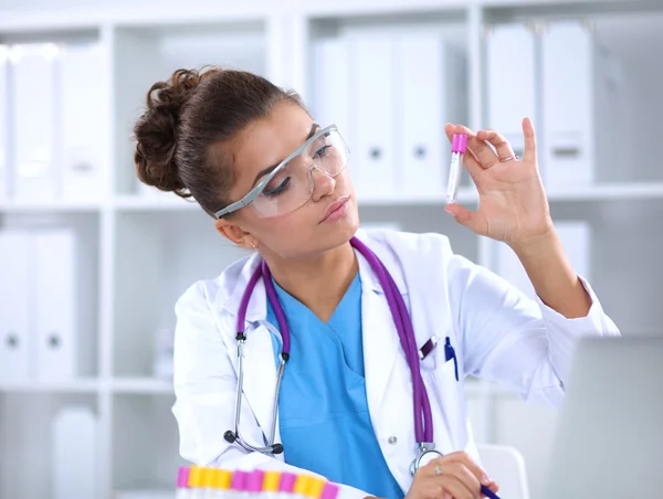Kvinnelig forsker er omgitt av medisinske hetteglass og målekolber, isolert på hvit bakgrunn – stockfoto
