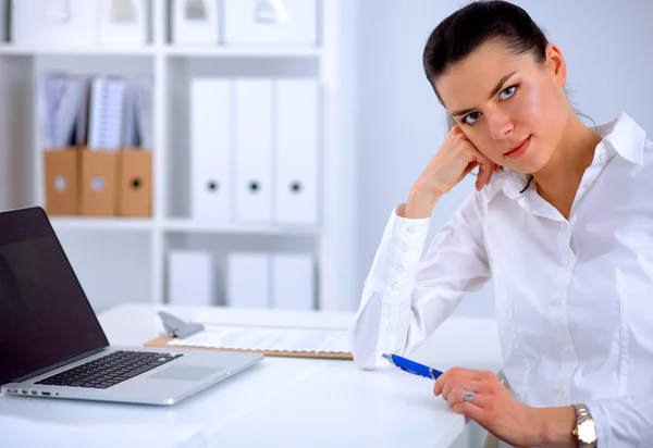 Atrakcyjna bizneswoman siedzi na biurku z laptopem w biurze — Zdjęcie stockowe