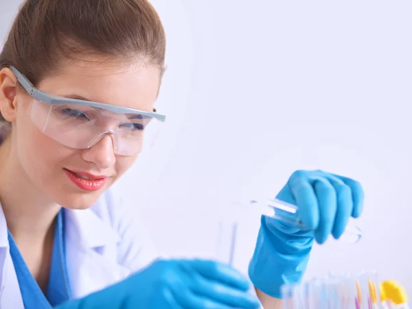 Woman researcher is surrounded by medical vials and flasks, isolated on white background — Stock Photo, Image