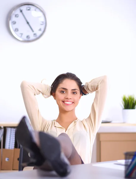 Деловая женщина расслабляется с руками за головой и сидит на офисном стуле — стоковое фото