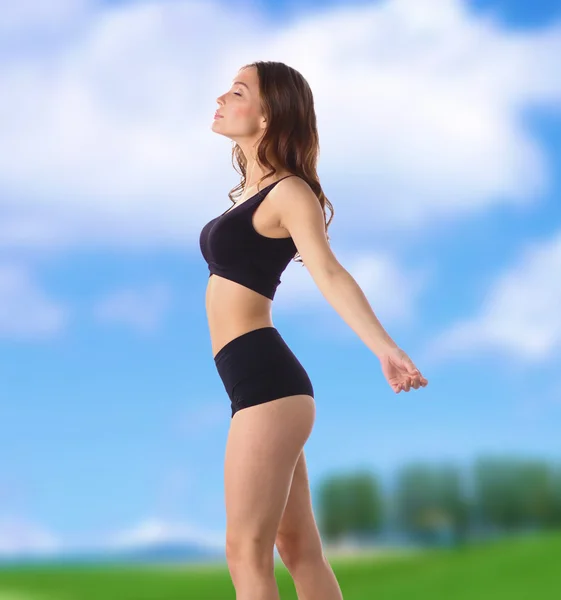 Chica de fitness joven de pie sobre hierba verde —  Fotos de Stock