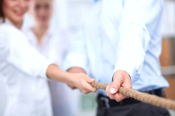 Konzeptbild eines Geschäftsteams, das ein Seil als Element der Teamarbeit im Vordergrund verwendet — Stockfoto