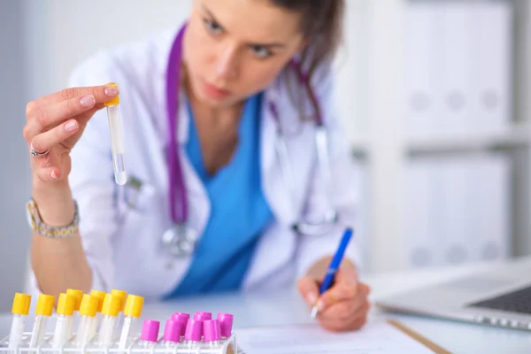 Woman researcher is surrounded by medical vials and flasks, isolated on white background — Stock Photo, Image