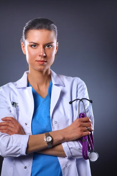 Retrato de una joven doctora sosteniendo un estetoscopio, aislada sobre fondo negro — Foto de Stock