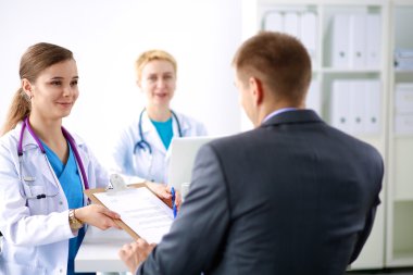 Tıp ekibi modern hastanedeki masada oturuyor.