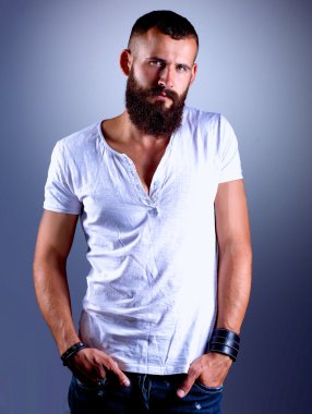 ayakta, gri arka plan üzerinde izole yakışıklı sakallı adam portresi