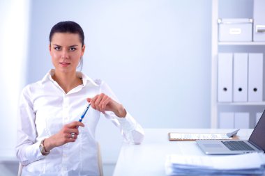Ofiste dizüstü bilgisayarı olan çekici bir iş kadını.