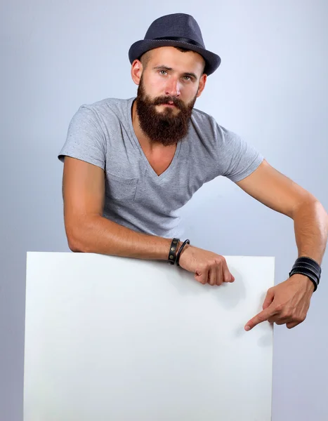 Portrait of young man in hat standing near blank, isolated on white background — Stock Photo, Image