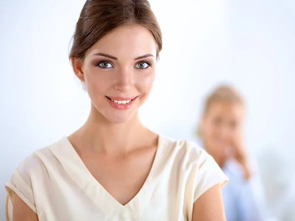 Attractive businesswoman standing near wall in office — Stock Photo, Image