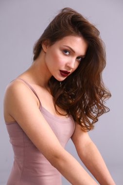 Gri arka planda izole edilmiş güzel bir kadının portresi.