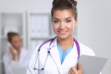 Hastanede üniformalı, gülümseyen bir kadın doktor.