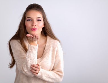  Genç kadın beyaz arka plan üzerinde izole bir hava öpücüğü veren