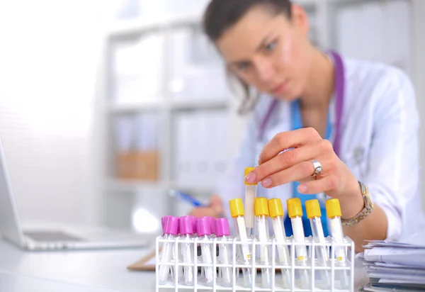 Woman researcher is surrounded by medical vials and flasks, isolated on white background — Stock Photo, Image